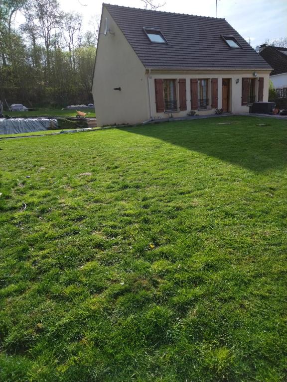 dom z dużym trawnikiem przed nim w obiekcie Agréable chambre double avec salle d'eau privative w mieście Le Mesnil-Théribus