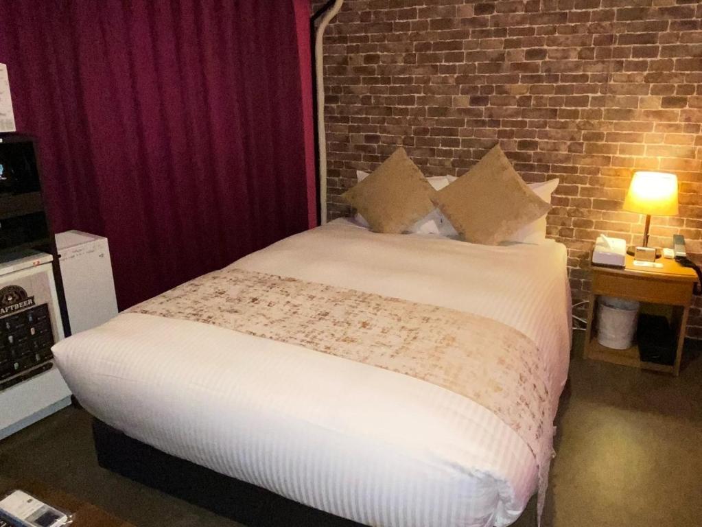 a bed in a room with a brick wall at Roppongi Plaza Hotel in Tokyo