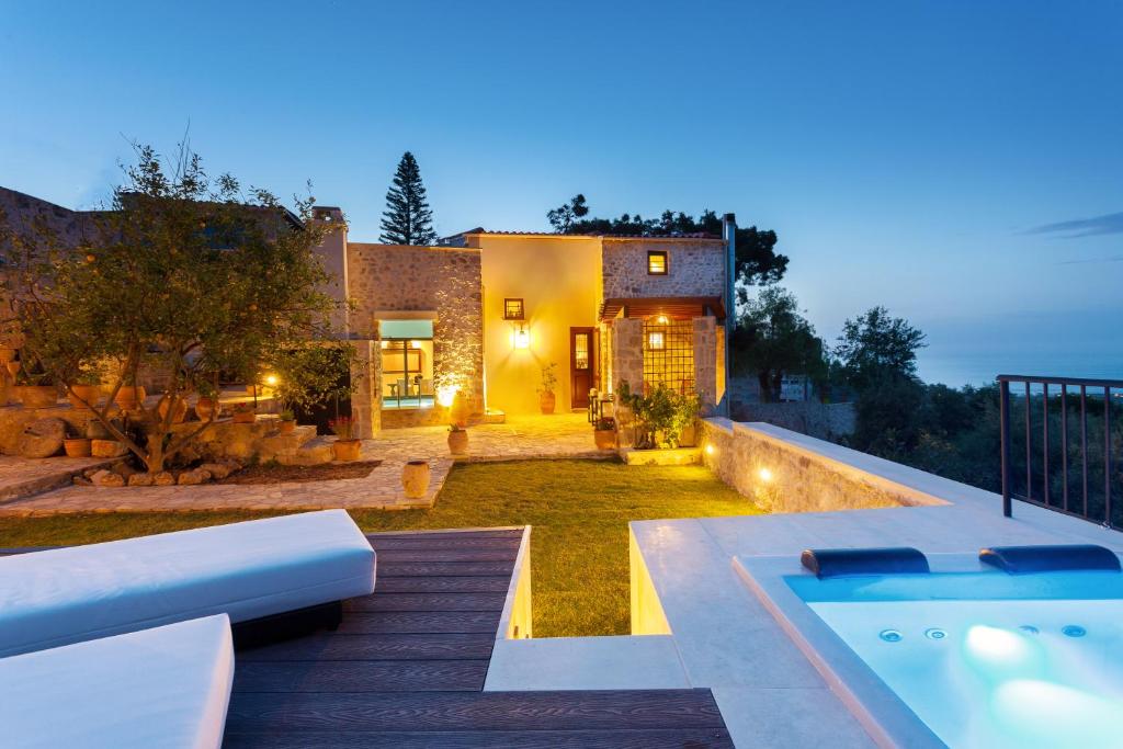 a home with a swimming pool and a house at Ali Vafi's Villa - Heated Jacuzzi & Indoor Pool in Maroulás