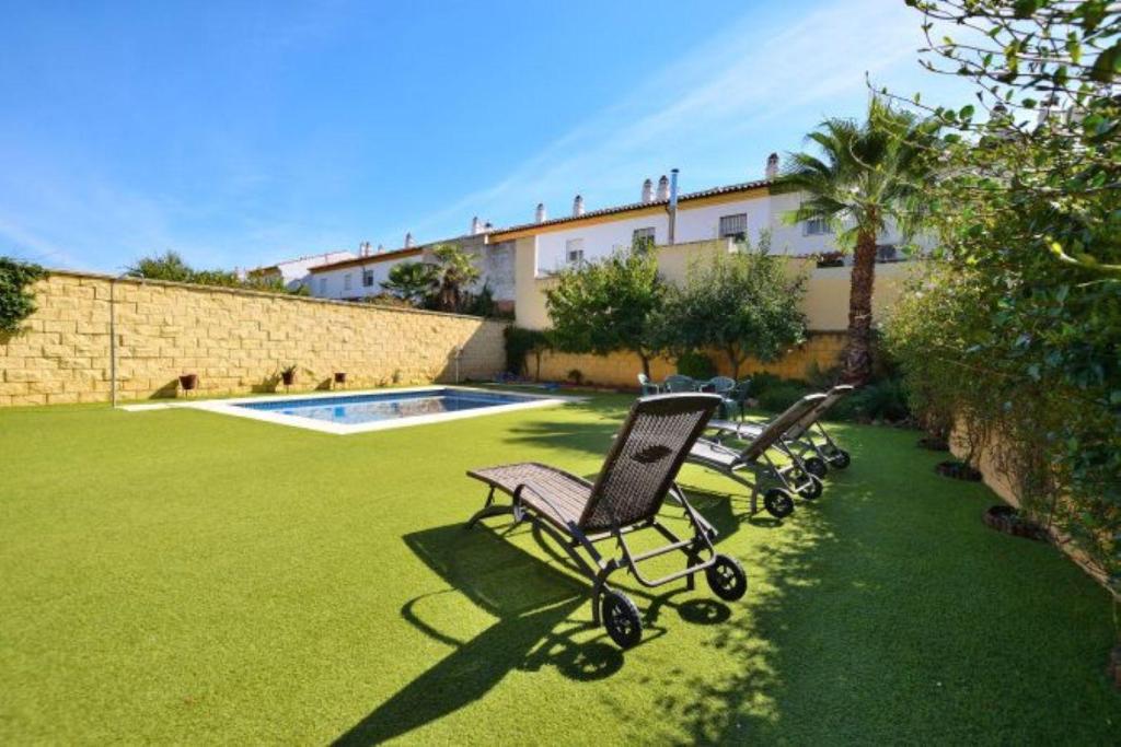 dos sillas de jardín sentadas en un patio con piscina en Can Sastre Ronda, en Ronda