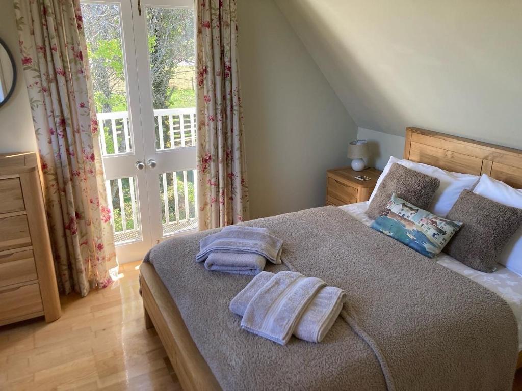 a bedroom with a bed with two towels on it at Plockton, Camus Fearn Barn in Plockton