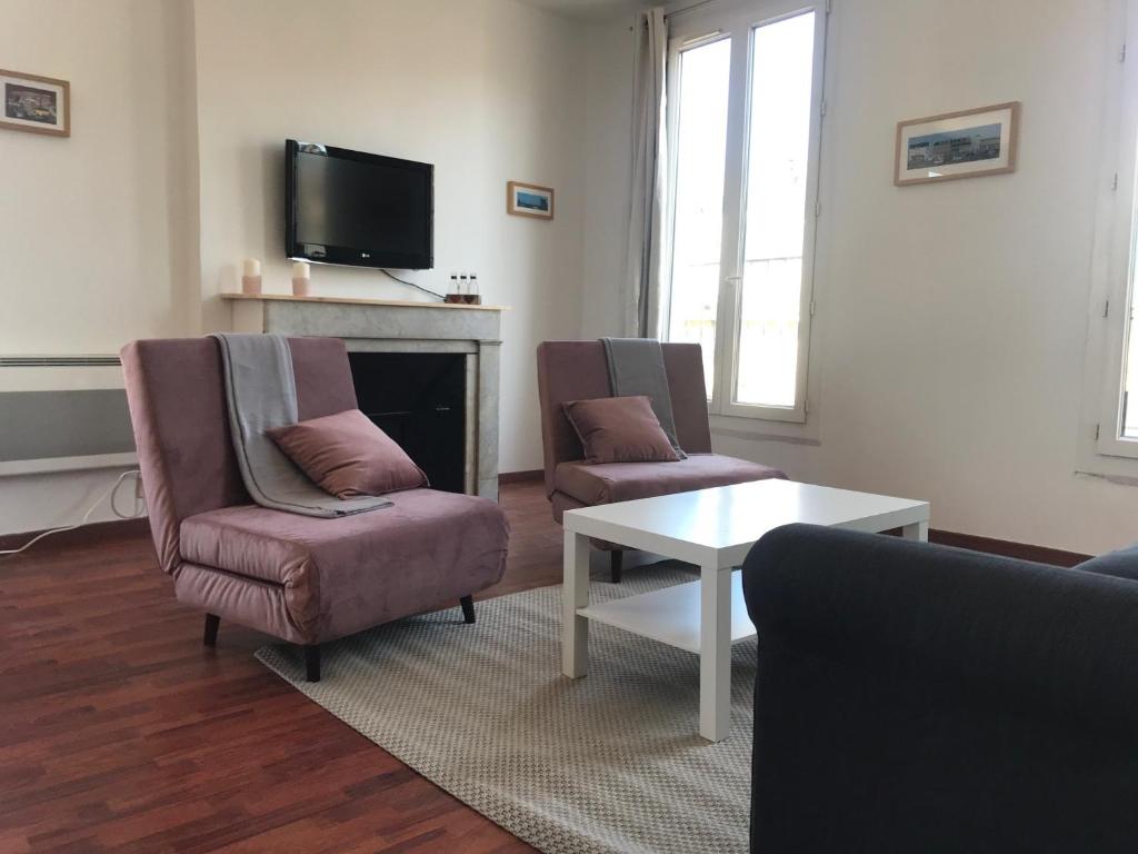 a living room with two chairs and a fireplace at Studio Moustier in Marseille