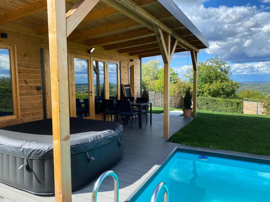 eine Terrasse mit einer Badewanne und einem Pool in der Unterkunft Woody House in Krčedin