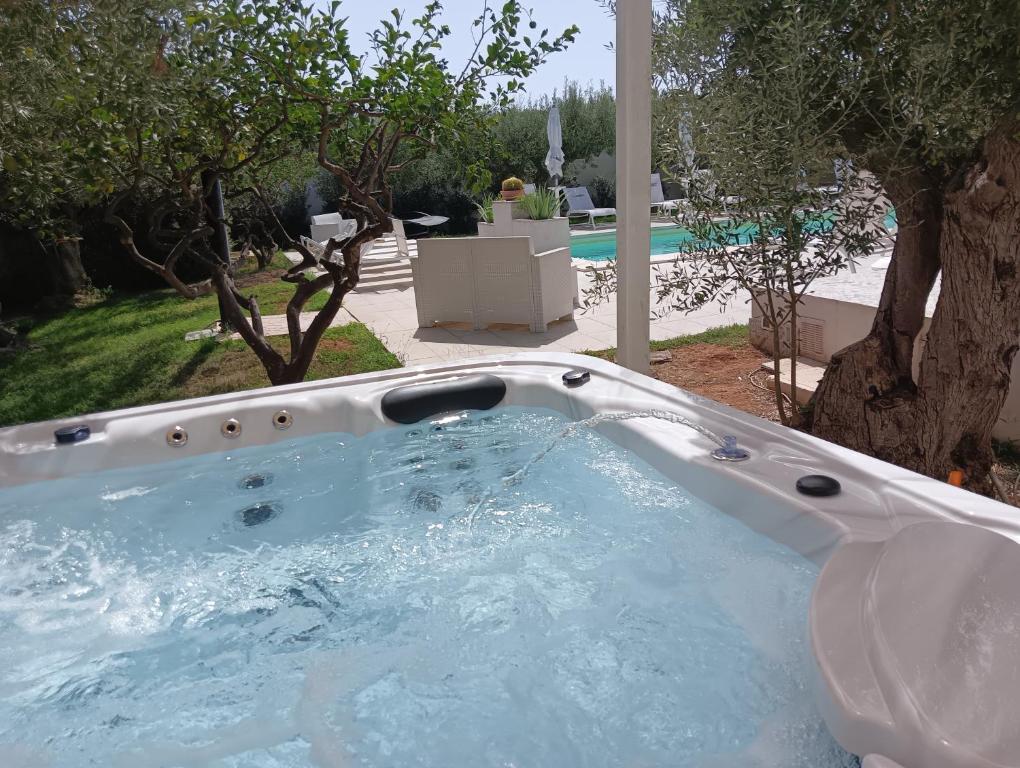 Signorino Eco Resort & Spa في مارسالا: حوض جاكوزي في ساحة مع مسبح