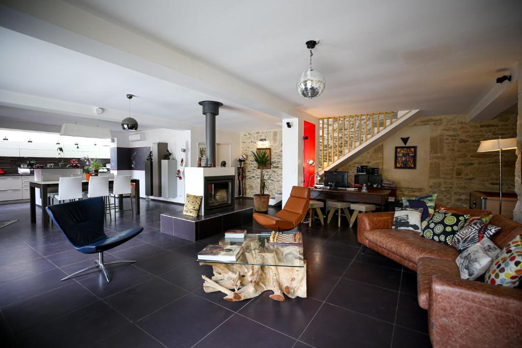 een woonkamer met banken en een tafel en een keuken bij Mas climatisé à 10 minutes de Montpellier in Lavérune