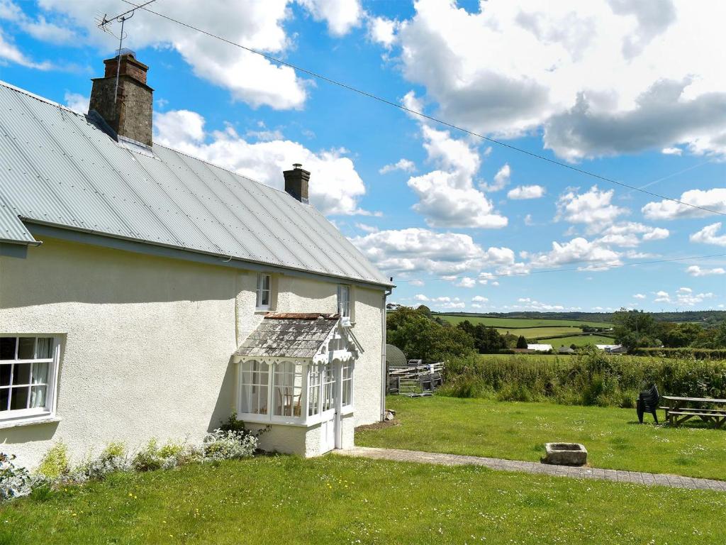 een wit huis met een raam aan de zijkant bij Well Farmhouse - Uk11880 in North Tamerton