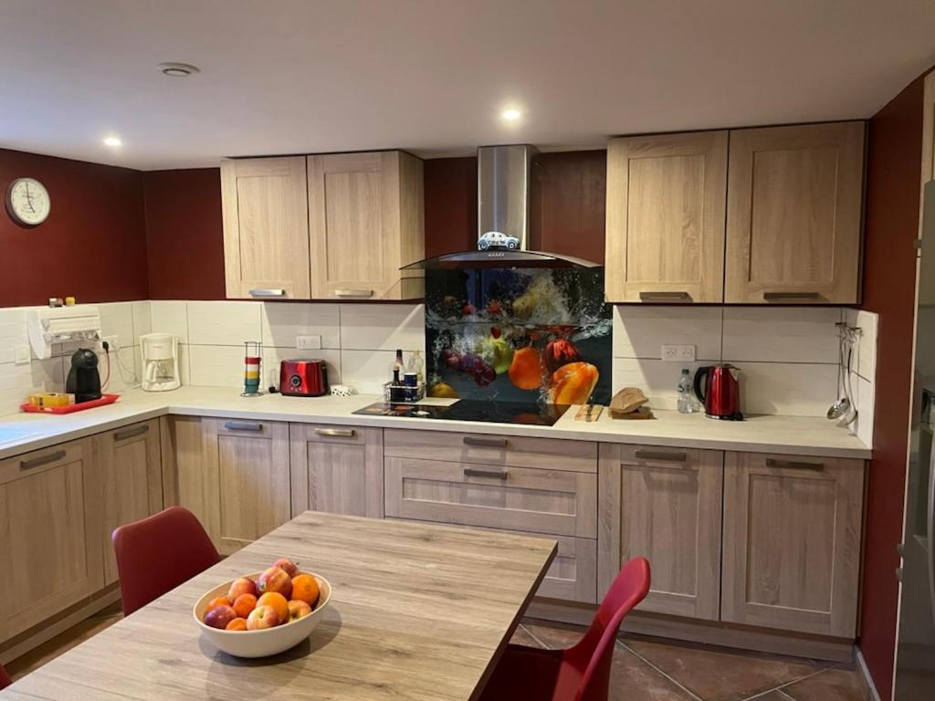 eine Küche mit einem Tisch und einer Obstschale darauf in der Unterkunft Les Meublés de Lassou Gîte in Lombers