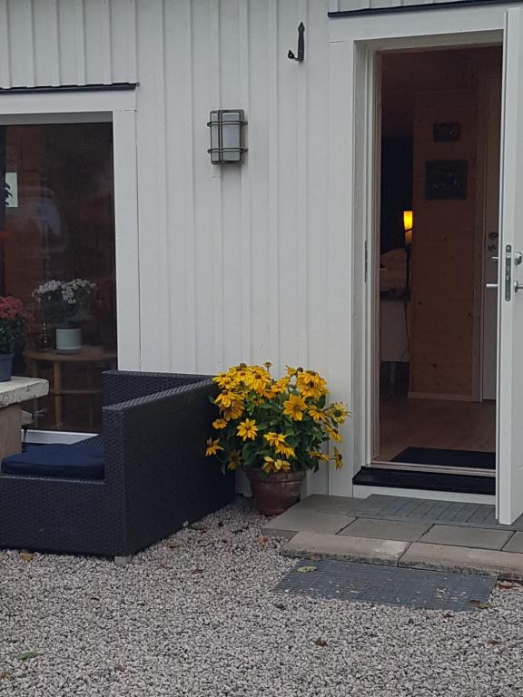 een voordeur van een huis met een bank en bloemen bij Raselund Gård in Vinninga