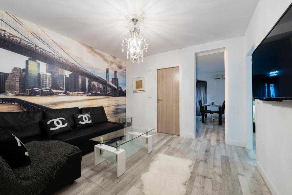 a living room with a black couch and a chandelier at Apartamentos Day Madrid CHUECA Centro Gran Via Sol Malasaña in Madrid