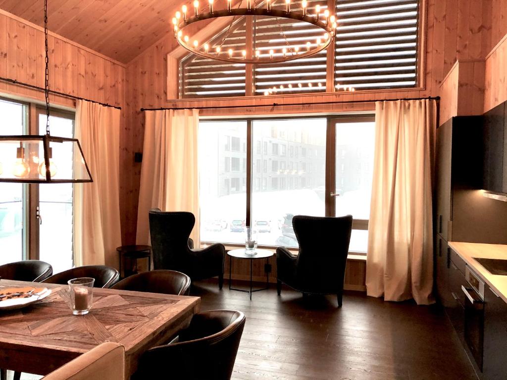 a dining room with a table and chairs and a large window at Fyri Tunet Hemsedal in Hemsedal