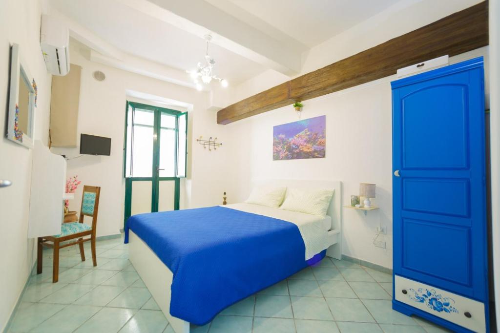 Un dormitorio con una puerta azul y una cama en ti Porto al Centro Unforgettable Moments, en Salerno