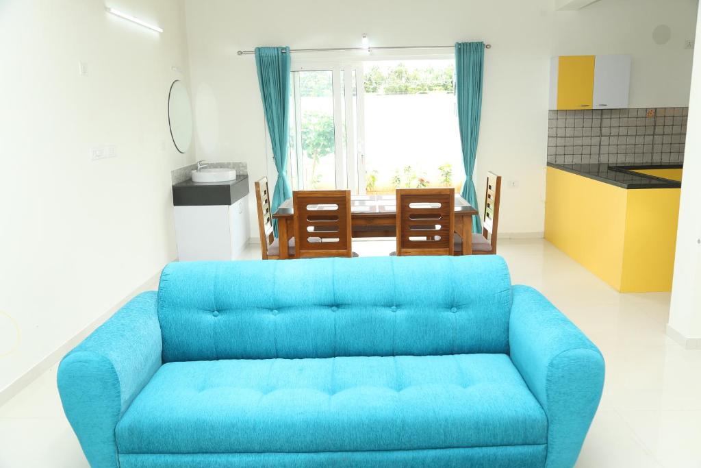 a blue couch in a living room with a table at The best villa stay- family friendly in Coimbatore