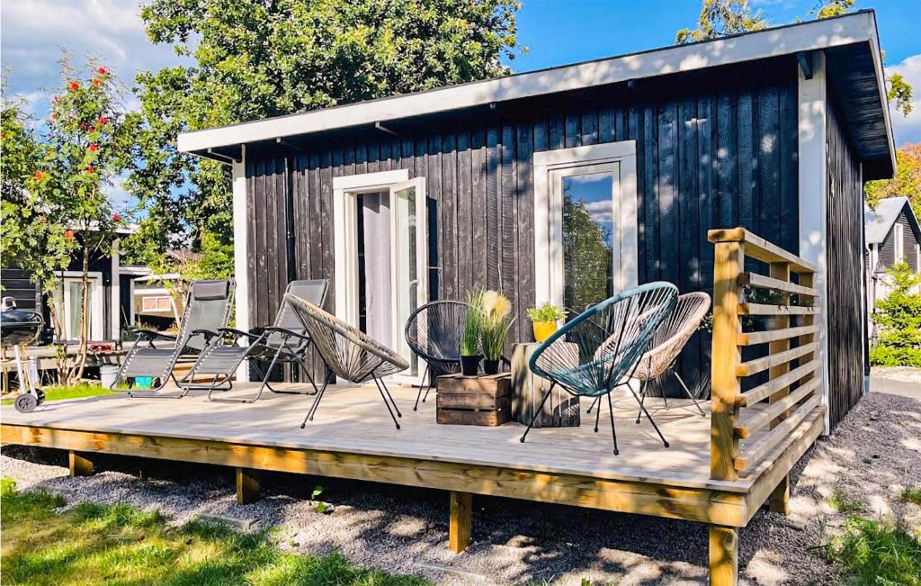 龍訥比的住宿－Stunning Home In Ronneby With Wifi，小木屋 - 带木甲板上的椅子