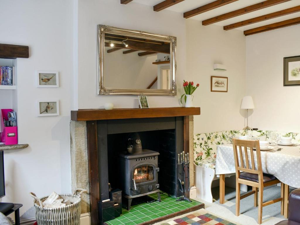 a living room with a fireplace and a mirror at Rose Cottage in Lofthouse