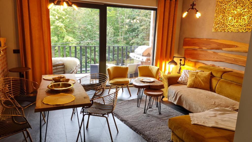 sala de estar con sofá, mesa y sillas en Apartament SPOKOLOKO Wiślańska Złoty B1 en Szczyrk