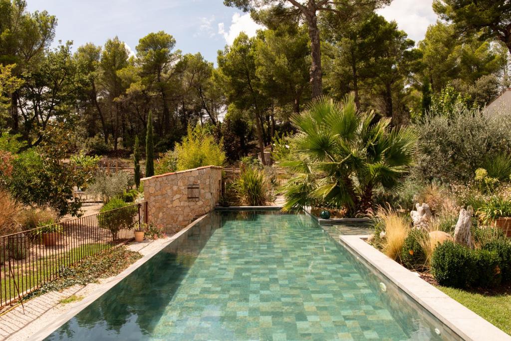 una piscina en un jardín con árboles en La Petite perle, balnéo en supplément, le Clos des Perles, en Tourtour