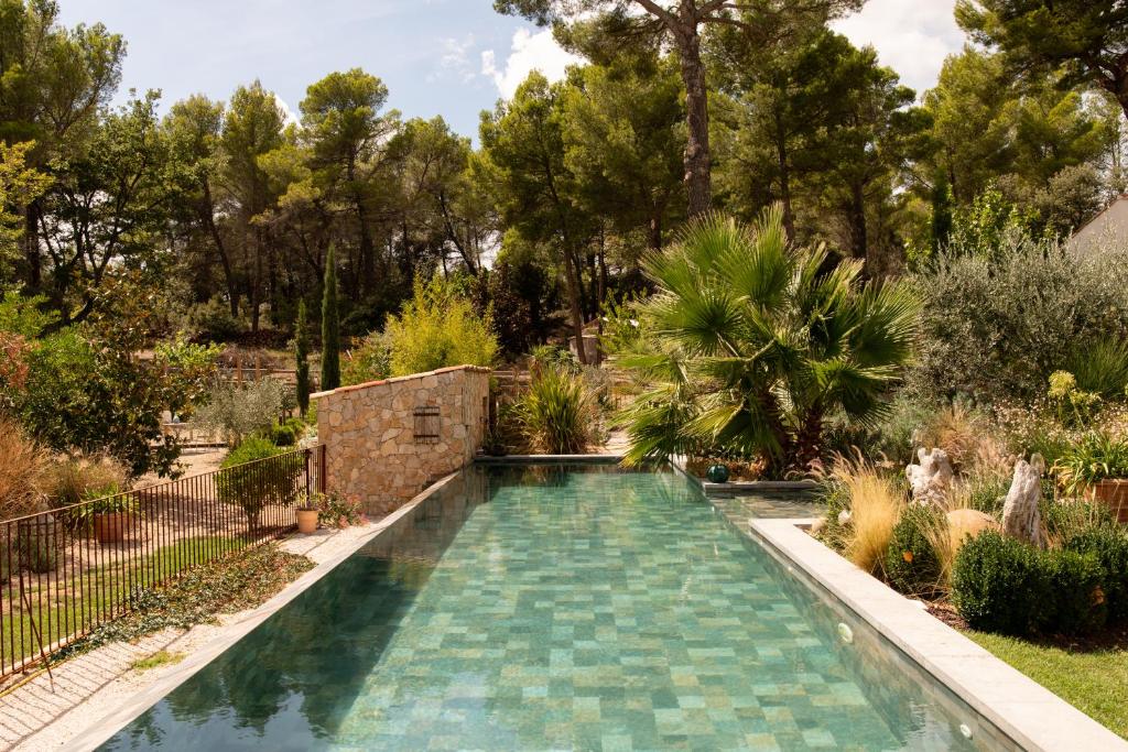 a swimming pool in a garden with trees at La Petite perle, balnéo en supplément, le Clos des Perles in Tourtour