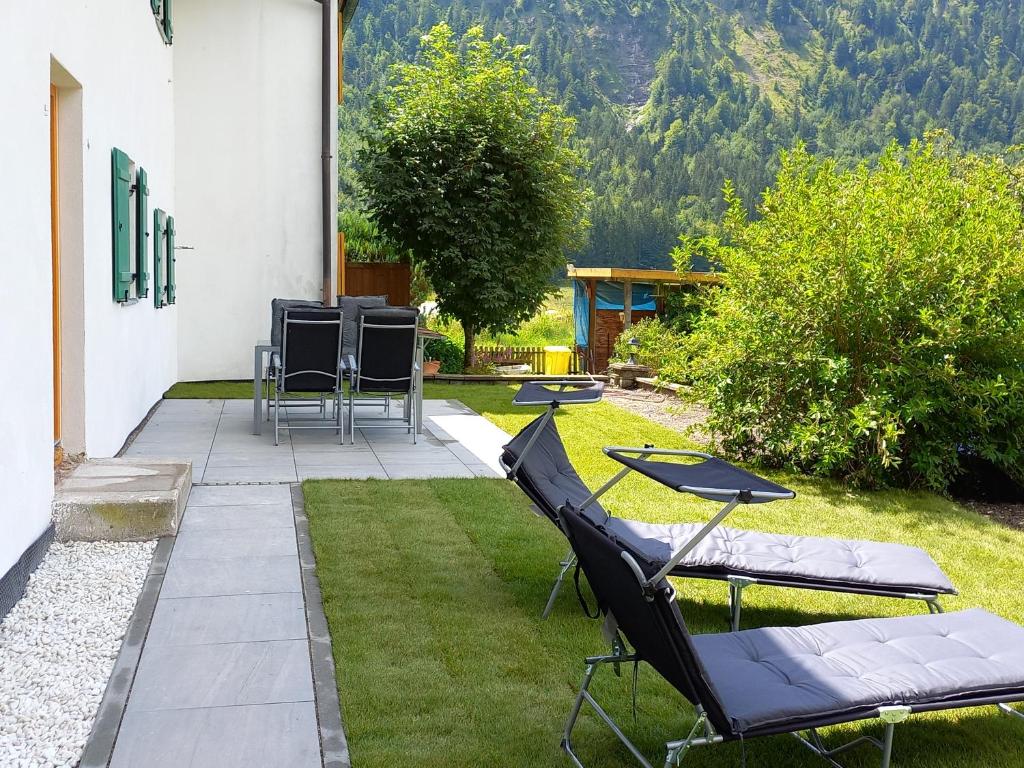 eine Terrasse mit Stühlen und einem Tisch im Gras in der Unterkunft Zur alten Schmiede in Ettal