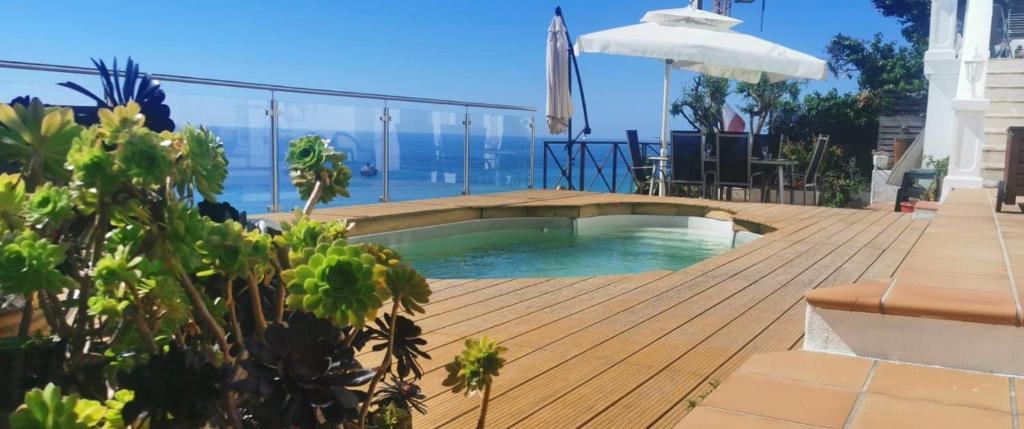 a swimming pool on a deck with a view of the ocean at Vue magnifique, piscine privée chauffée et sauna à 10min de Monaco in Roquebrune-Cap-Martin