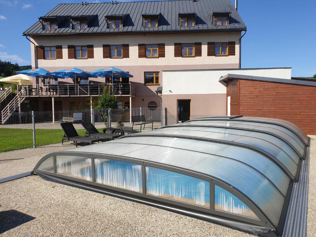 a glass roofed building with a building in the background at Hotel Park in Ostružná