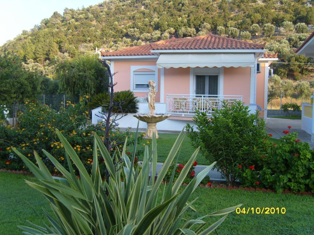 a pink house with a fountain in a yard at Elisabeth Villas in Kerveli