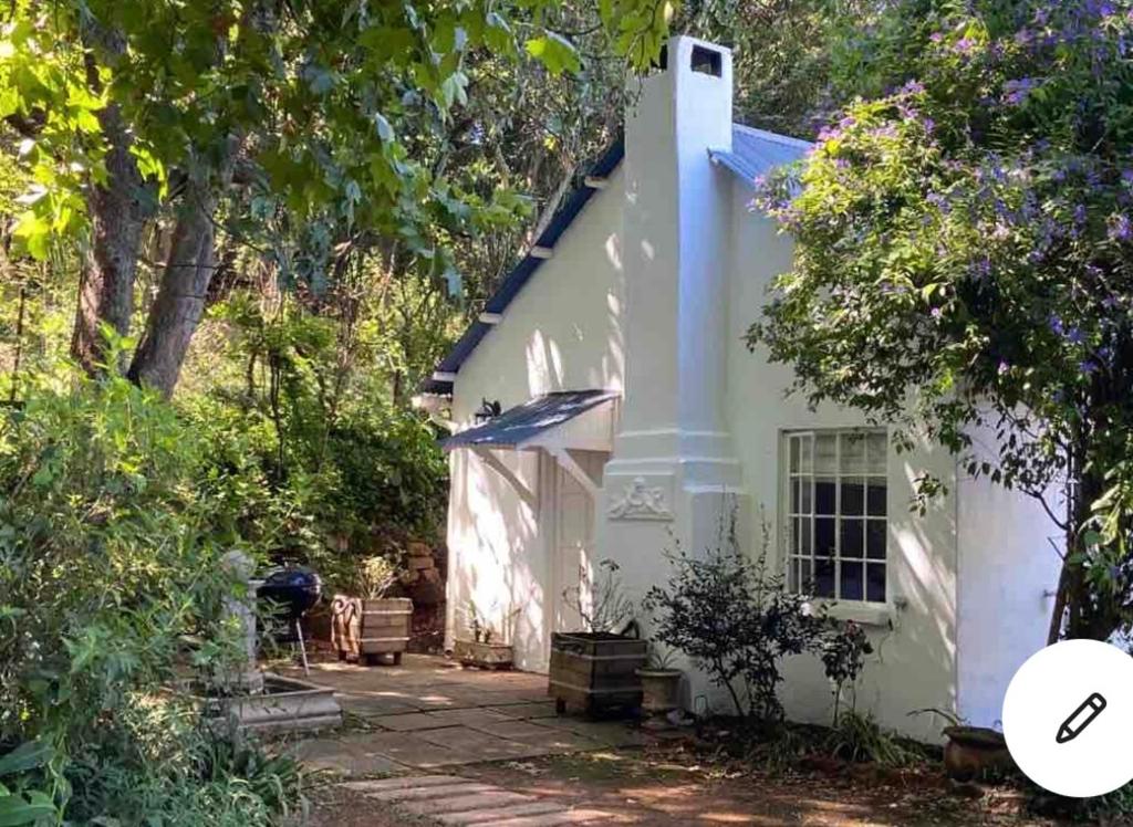 a white house with a pathway leading to it at Yellowwoods Farm - POOL COTTAGE (self-catering) in Curryʼs Post
