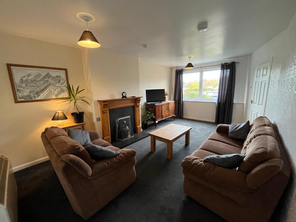 a living room with two couches and a fireplace at Inverness House in Inverness