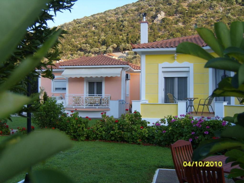 a yellow and pink house with a hill in the background at Elisabeth Villas in Kerveli