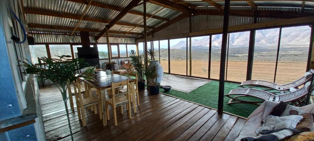 salon ze stołem i krzesłami na drewnianej podłodze w obiekcie Windy Rose - Rustic Karoo Villa w mieście Barrydale