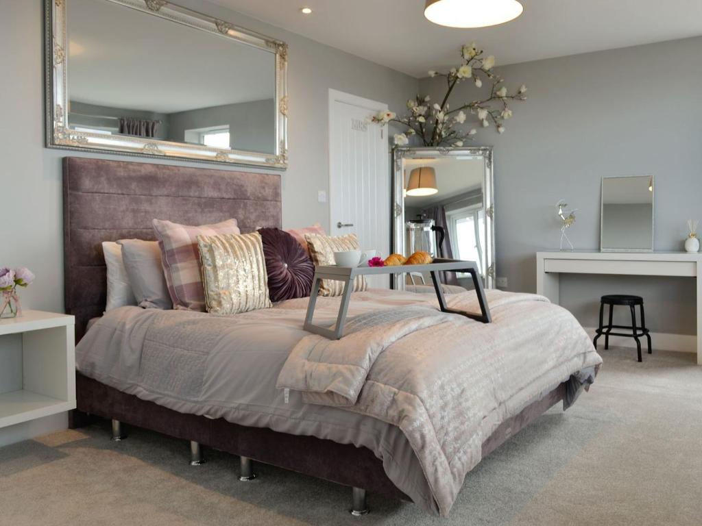sypialnia z dużym łóżkiem z dużym lustrem w obiekcie Hillside Retreat w mieście Prestatyn