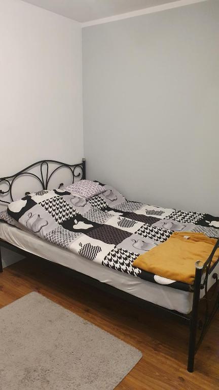 a bed with a black and white comforter on it at Pokój X in Stegna