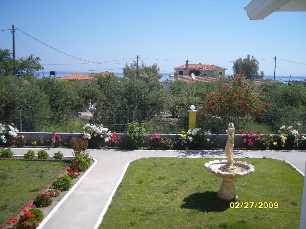 a statue in the middle of a garden with flowers at Elisabeth Villas in Kerveli