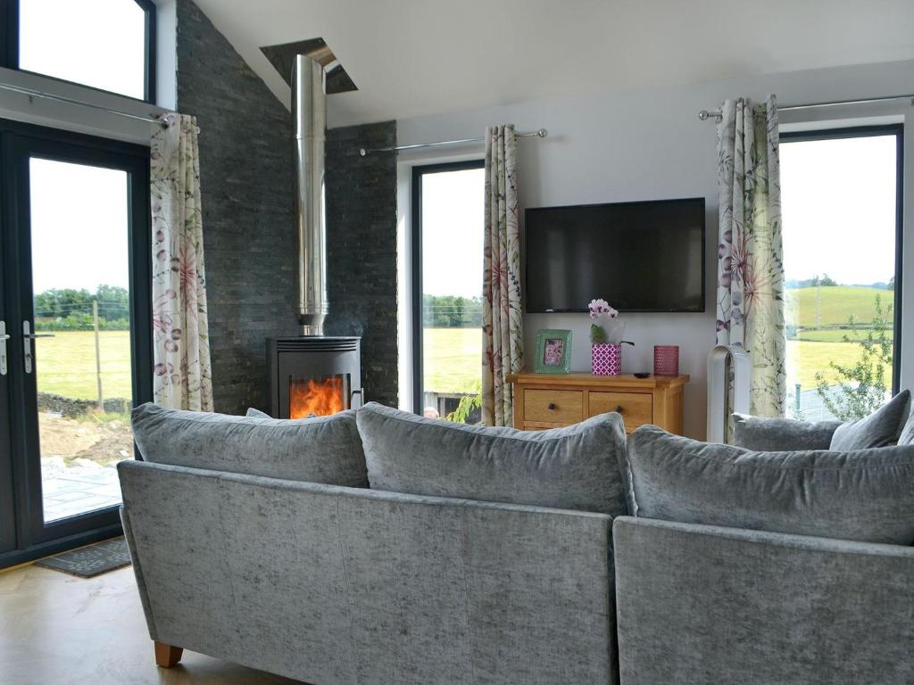 a living room with a couch and a fireplace at Sprint Lodge in Burneside