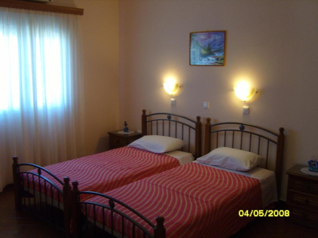 a bedroom with two beds and a window at Elisabeth Villas in Kerveli