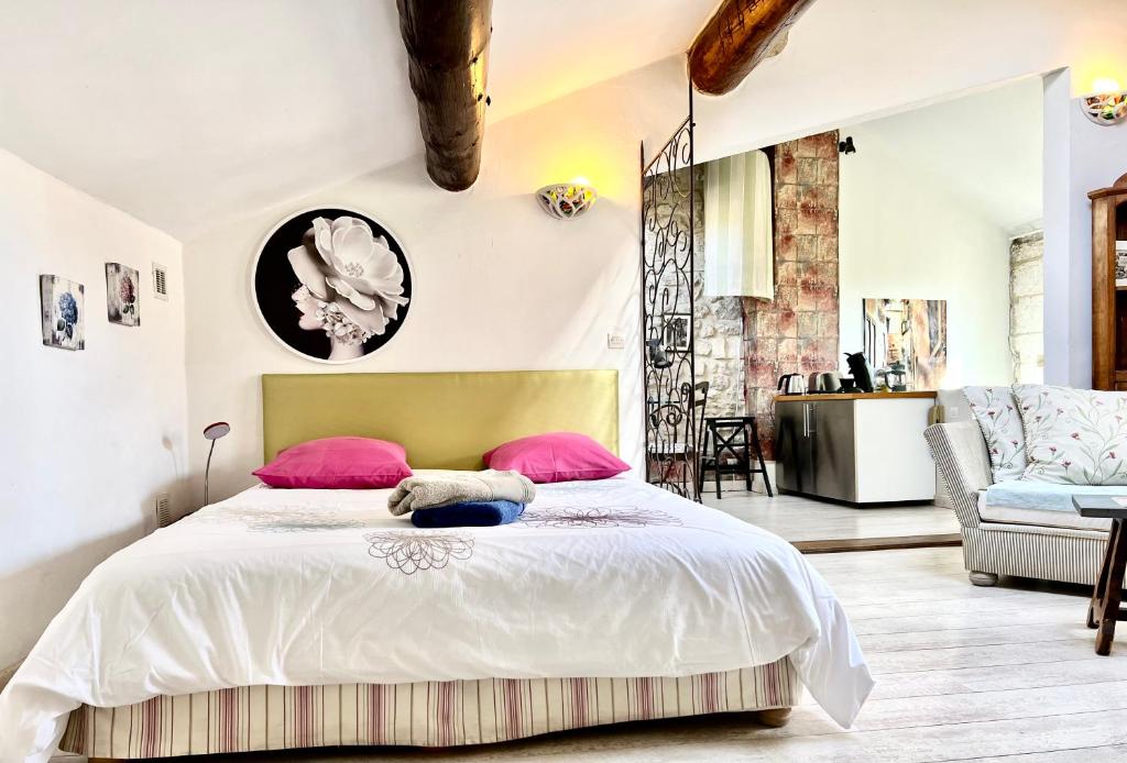 a bedroom with a large bed with pink pillows at Studio St Rémy Historic Center/Air-com in Saint-Rémy-de-Provence