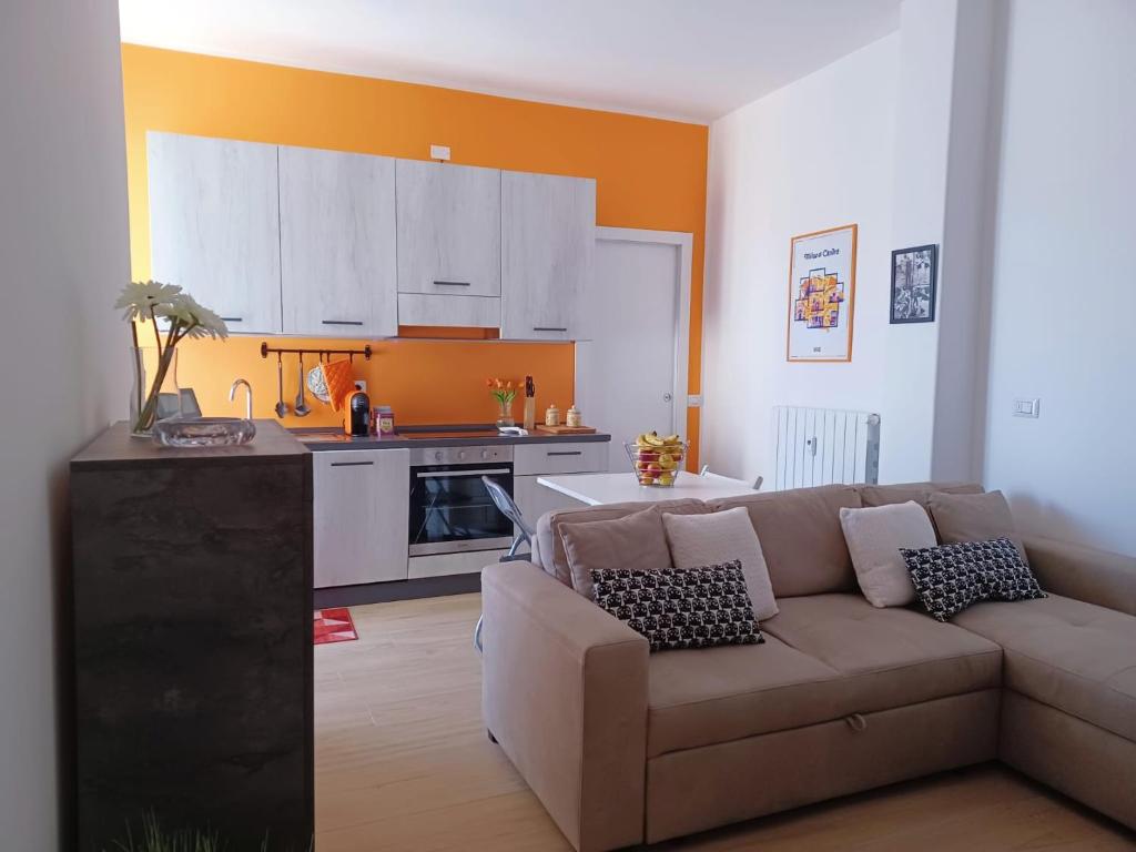 een woonkamer met een bank en een keuken bij Joy Home 31 in Milaan