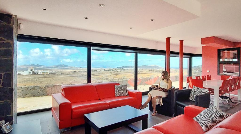 VillaverdeにあるLuxury Villa Sand Volcanoの砂漠の景色を望むリビングルームに座る女性