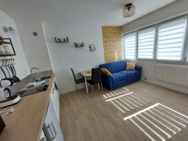 a living room with a blue couch and a table at Mon beau studio in Vesoul