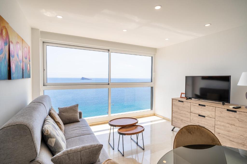 a living room with a couch and a large window at Santa Margarita - Benisun in Benidorm