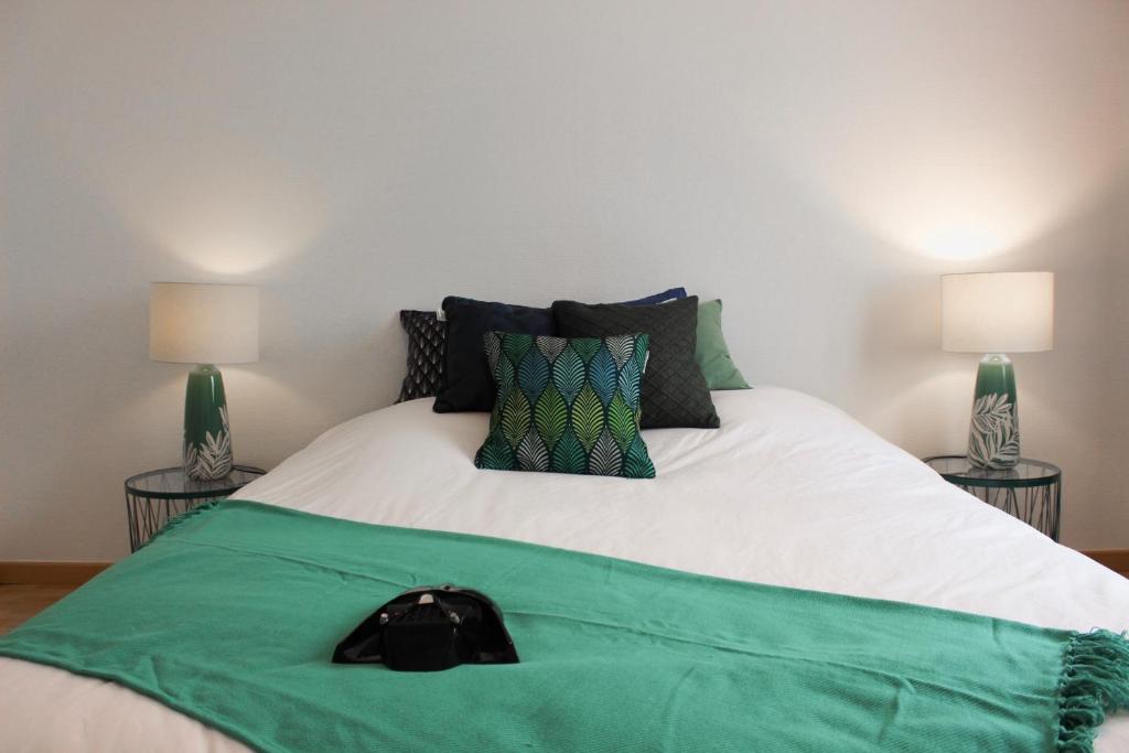 un letto con una coperta verde su di esso con due lampade di HAPPY MAMA COLMAR with PARKING a Colmar