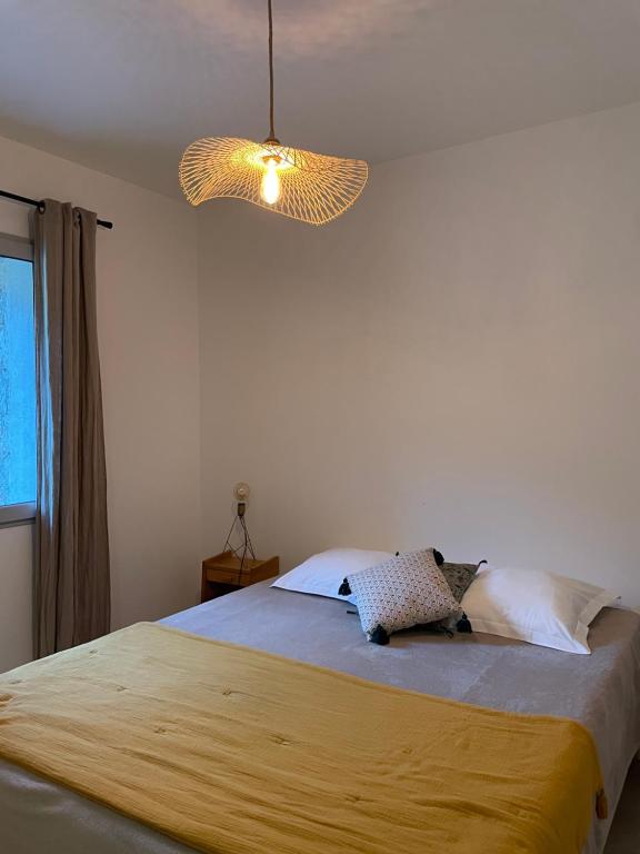 a bedroom with a large bed with a light at Résidence Casarella Lama in Lama