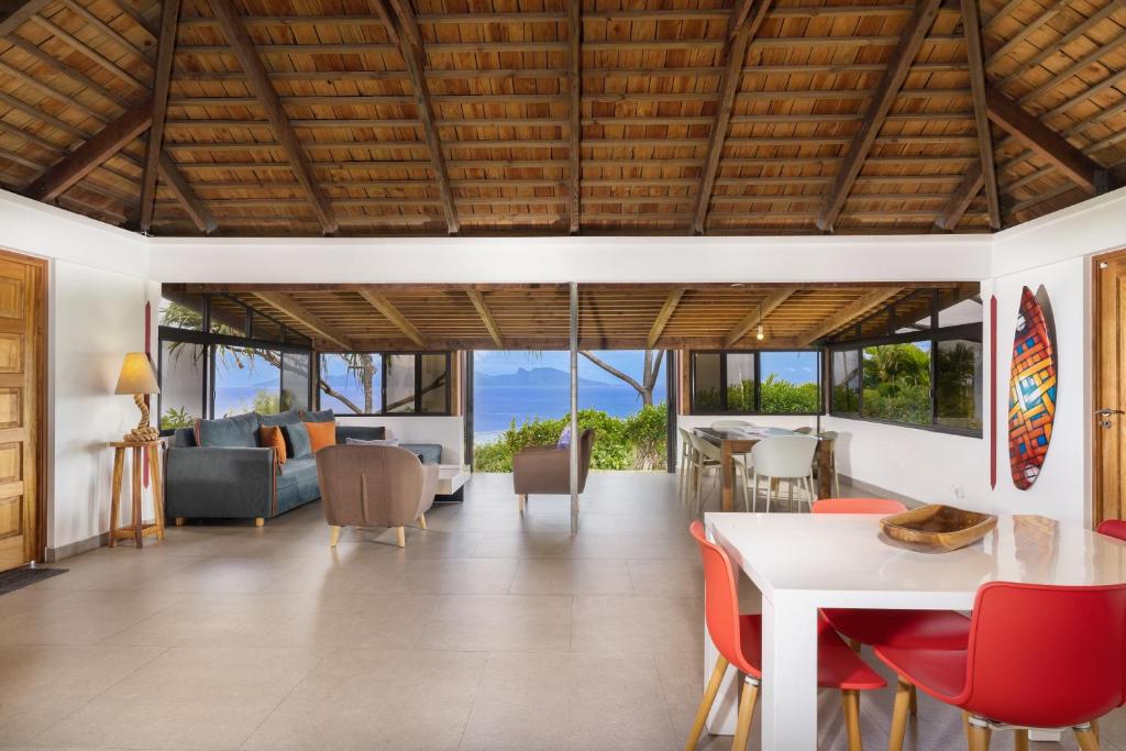 sala de estar de planta abierta con mesa y sillas en Jolie Maison Vue Ocean et Moorea en Punaauia