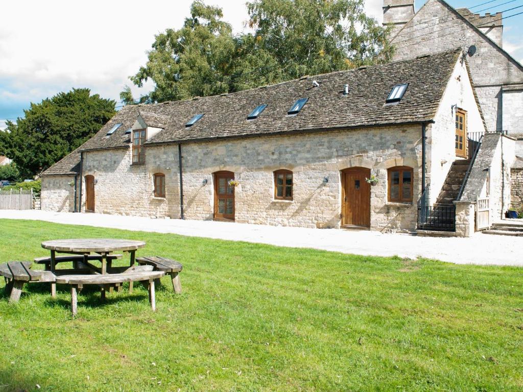 a picnic table in front of a stone building at Stanley Barn in Stonehouse