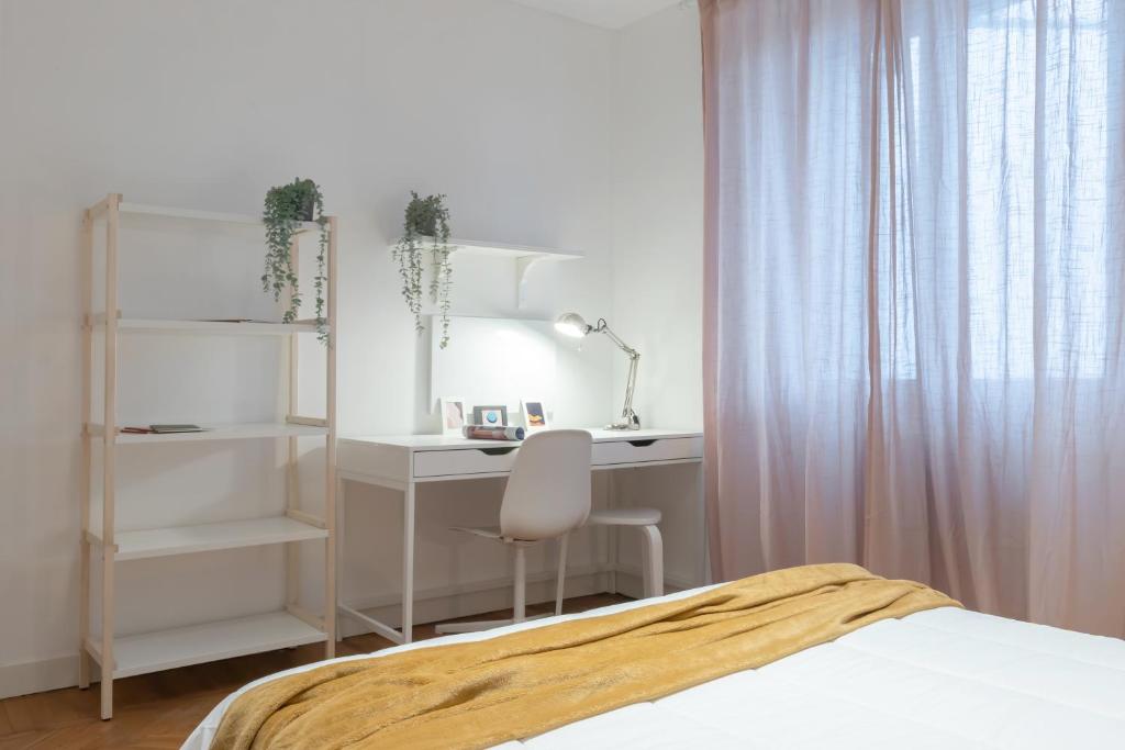 biała sypialnia z biurkiem i łóżkiem w obiekcie Top Living Apartments - Carducci w Turynie