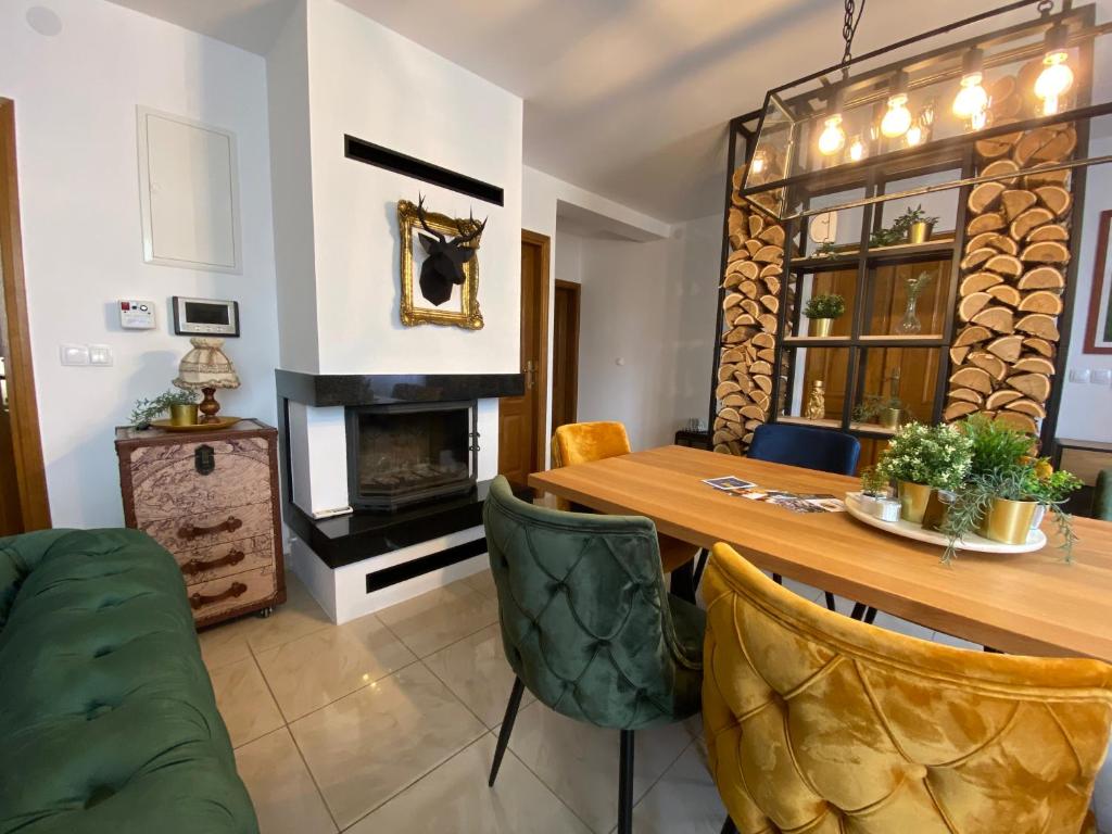 a dining room with a table and a fireplace at Holiday home Casa Rio in Vinkovci