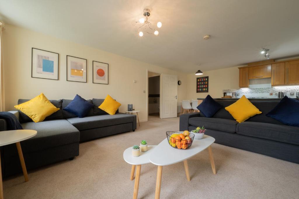 een woonkamer met banken en een tafel met fruit erop bij Luxury 2-bedroom 2-bathroom city centre apartment in Lichfield
