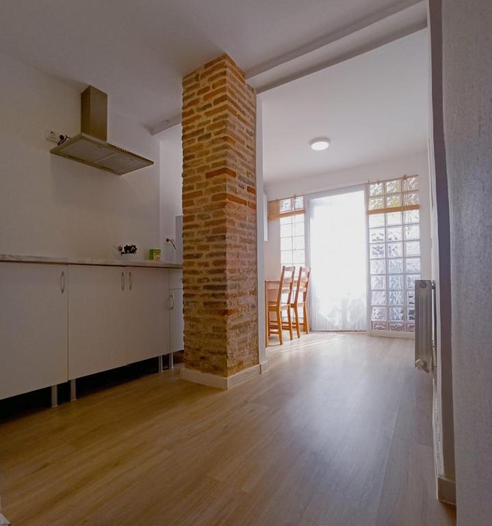 an empty room with a brick wall and a kitchen at Apto céntrico INDUSTRIAS VUT 47-215 in Valladolid