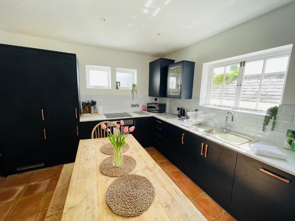 a kitchen with a wooden table with a vase on it at NomiHomes-Otis House-Free Parking x 2-Central -10ppl in Exeter