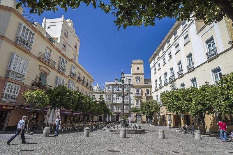 een straat met gebouwen en mensen die rondlopen bij La Casita del Arte in Cádiz