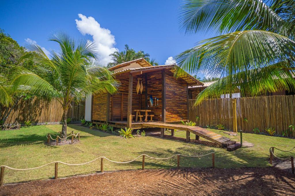 uma casa de madeira com um deque de madeira e um quintal em Cabana Fluir - Taipu de Fora - Península de Maraú em Barra Grande